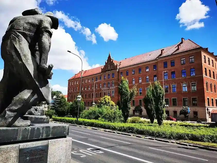 Budynek Uniwersytetu Rolniczego im. Hugona Kołłątaja w Krakowie z pomnikiem na pierwszym planie – hologramy na legitymacje studenckie i doktoranckie