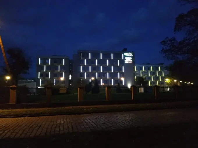 Nocny widok oświetlonego budynku Akademii Wojsk Lądowych we Wrocławiu